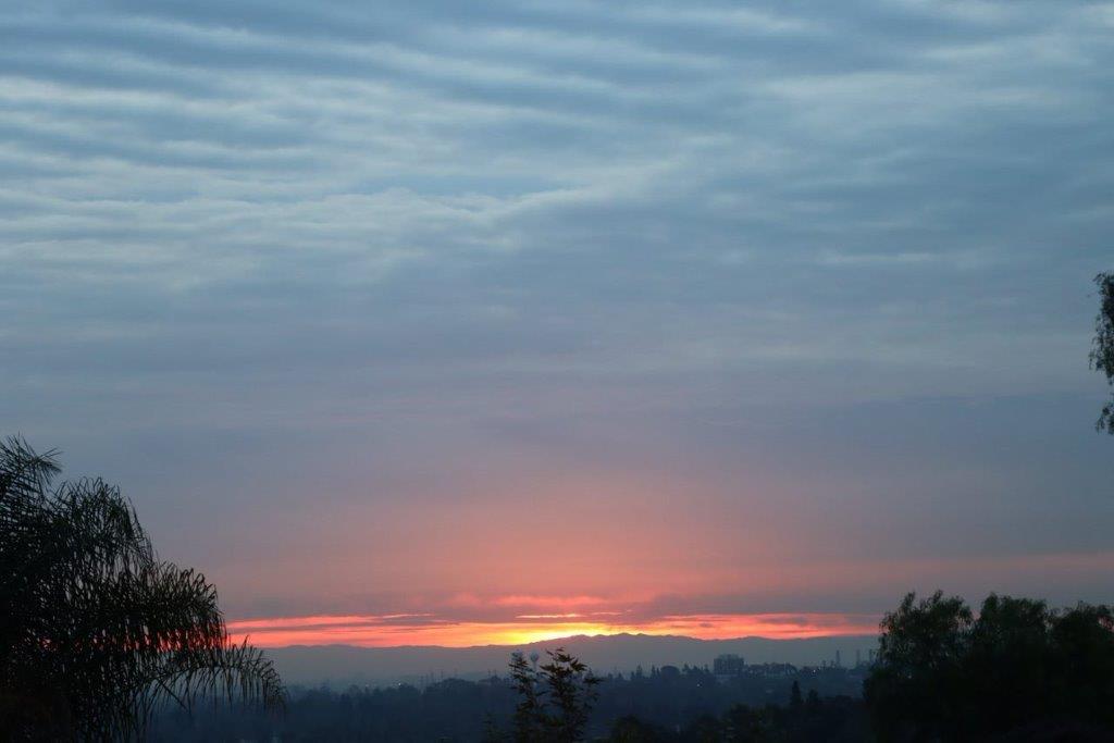 A sunset over a city

Description automatically generated