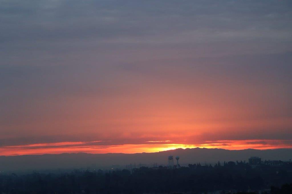 A sunset over a city

Description automatically generated