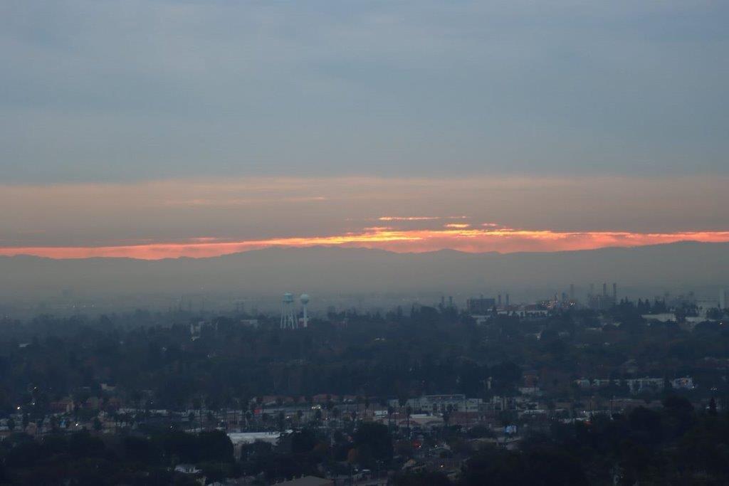 A sunset over a city

Description automatically generated