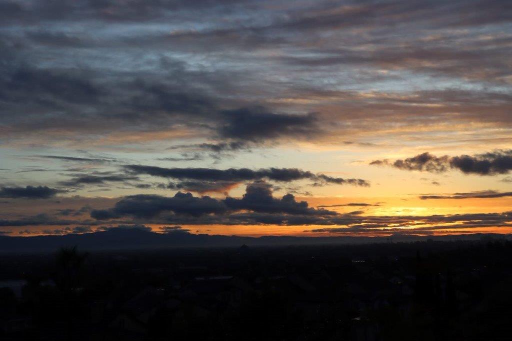 A sunset over a city

Description automatically generated