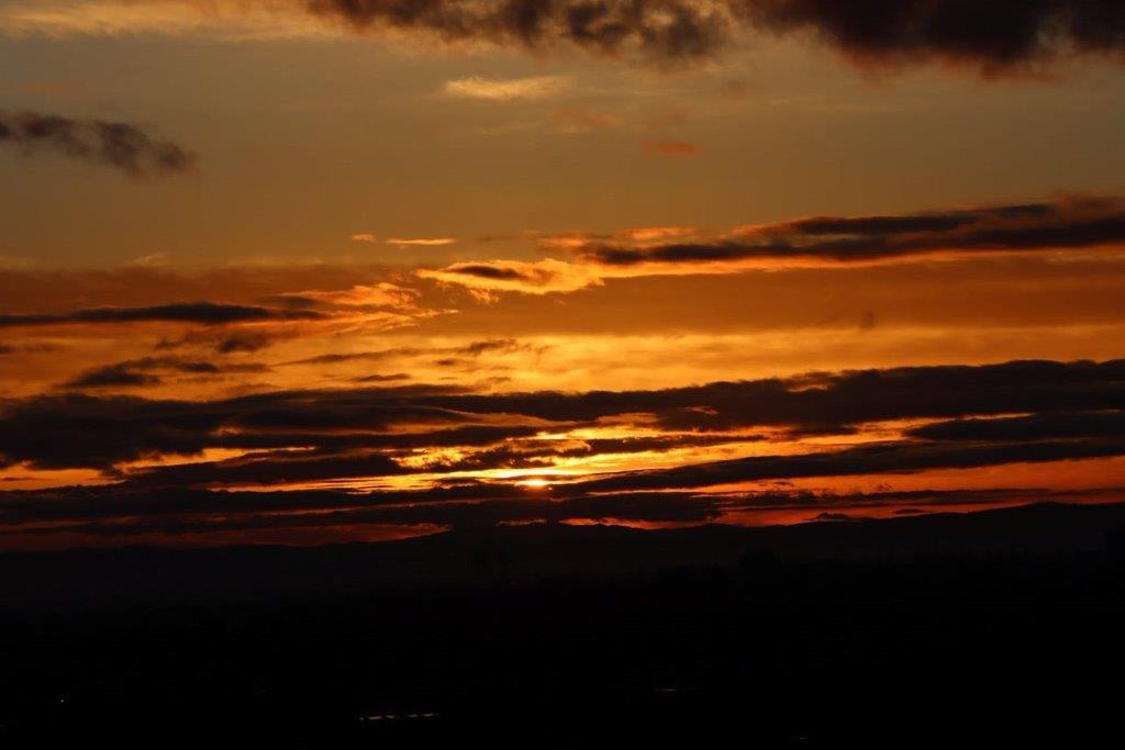 A sunset with clouds in the sky

Description automatically generated
