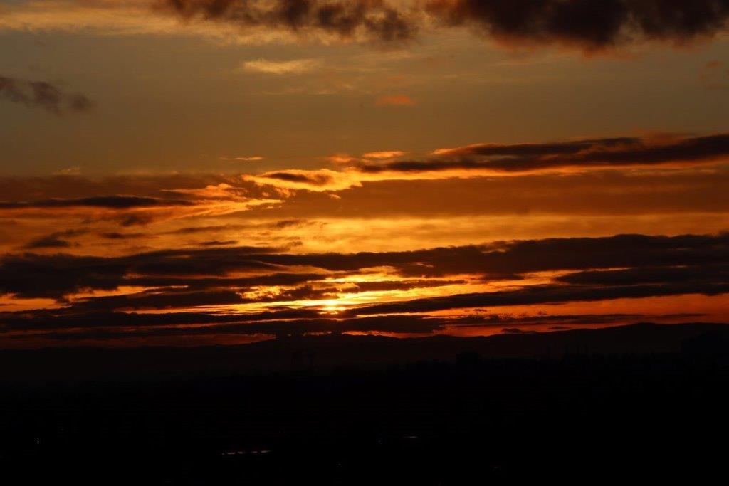 A sunset with clouds in the sky

Description automatically generated