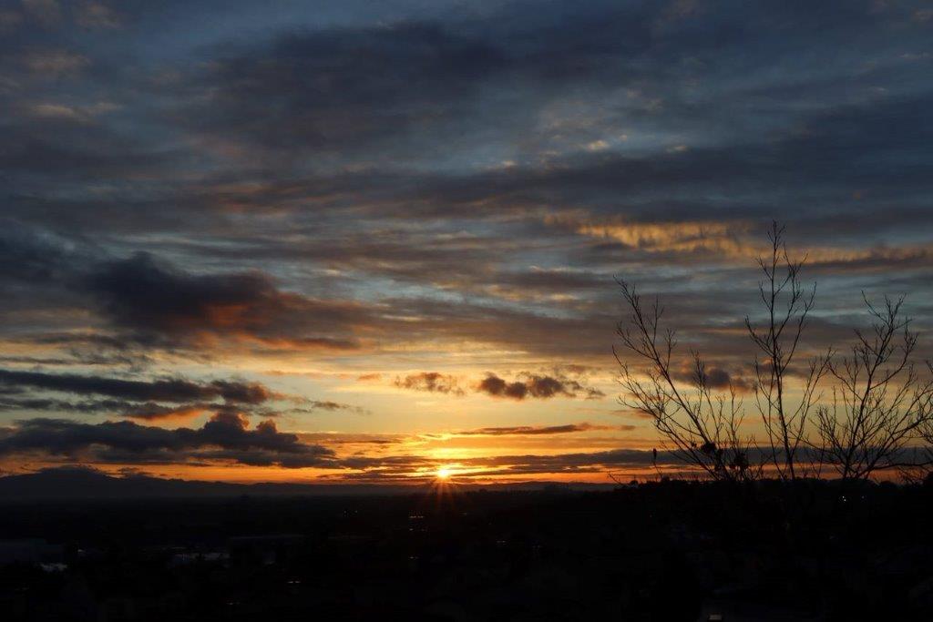 A sunset over a city

Description automatically generated