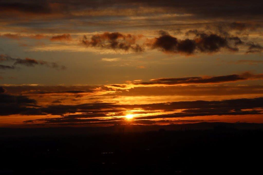 A sunset over a city

Description automatically generated