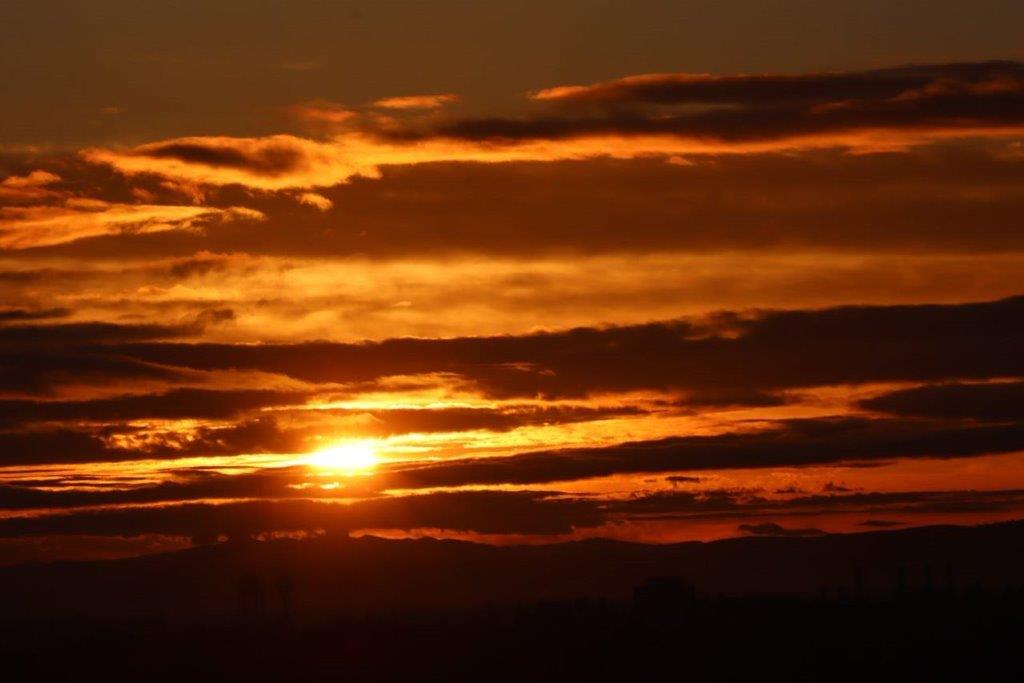 A sunset with clouds in the sky

Description automatically generated