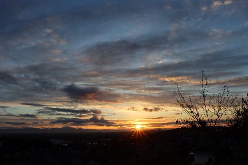 A sunset over a city

Description automatically generated