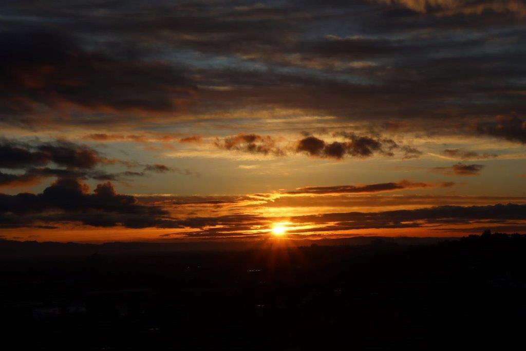 A sunset over a city

Description automatically generated