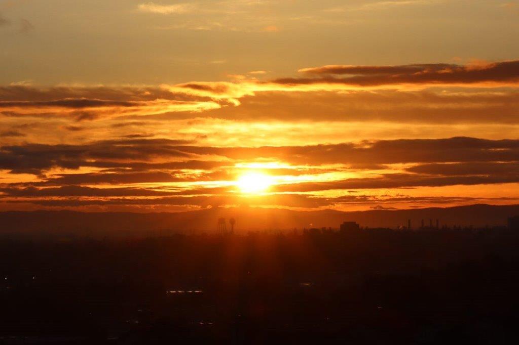 A sunset over a city

Description automatically generated