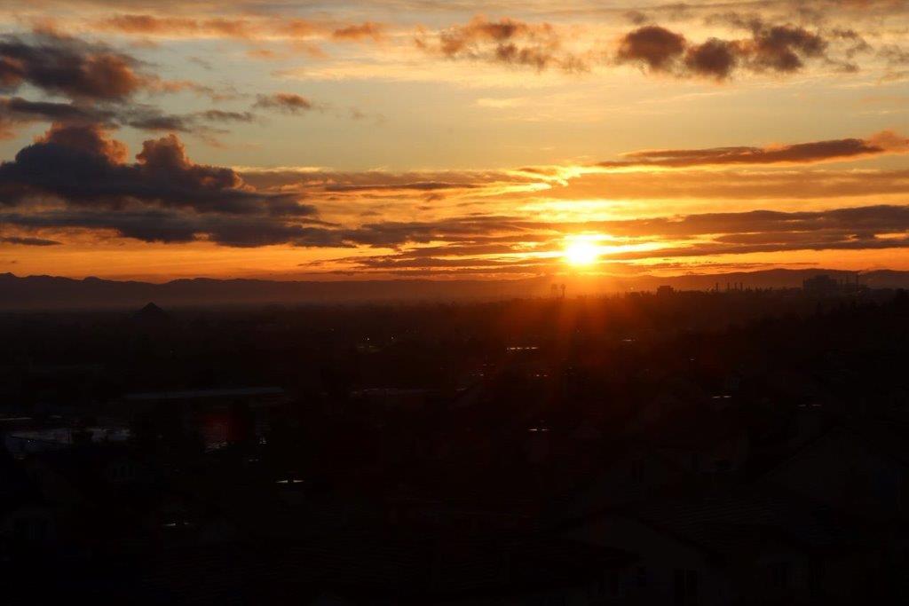 A sunset over a city

Description automatically generated