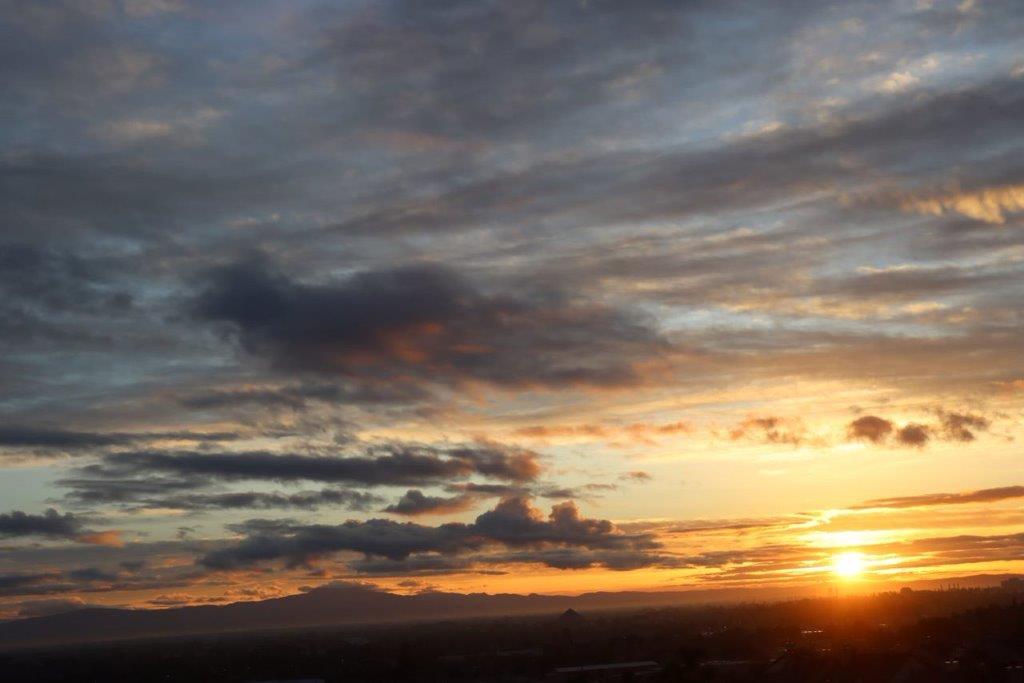 A sunset over a city

Description automatically generated
