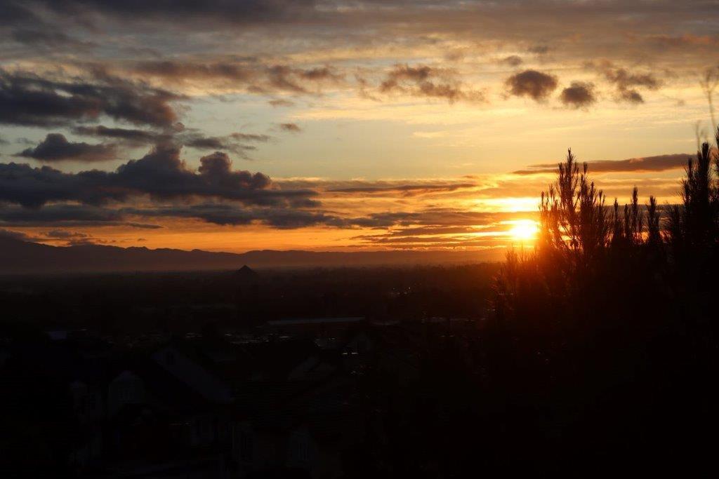 A sunset over a city

Description automatically generated