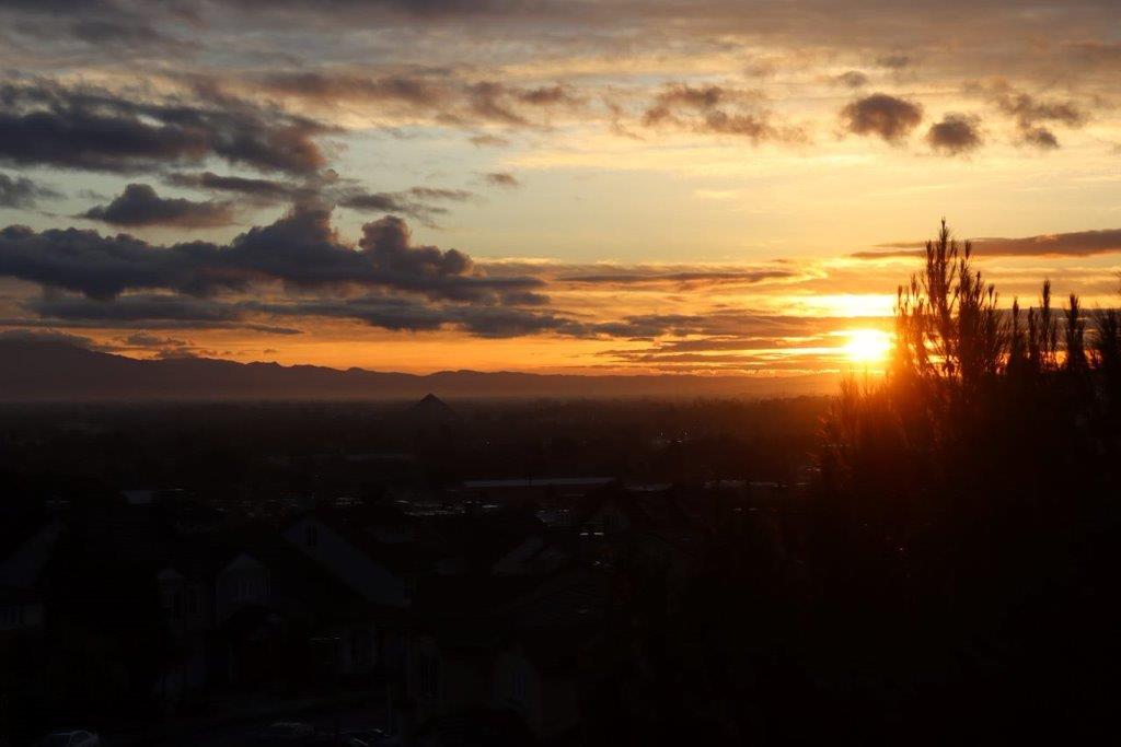 A sunset over a city

Description automatically generated