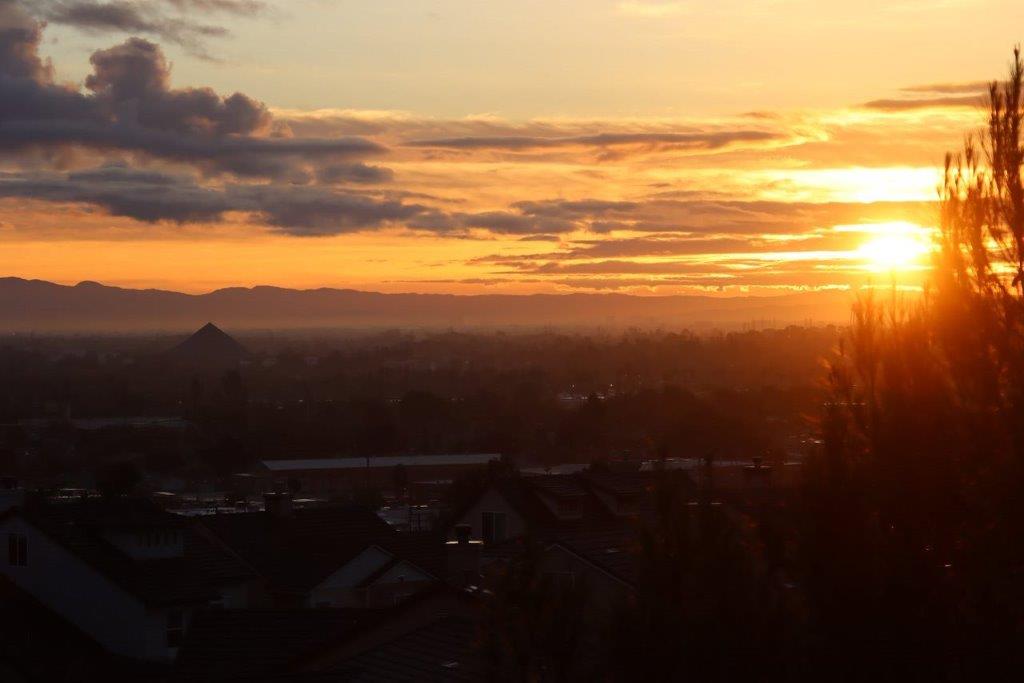 A sunset over a city

Description automatically generated