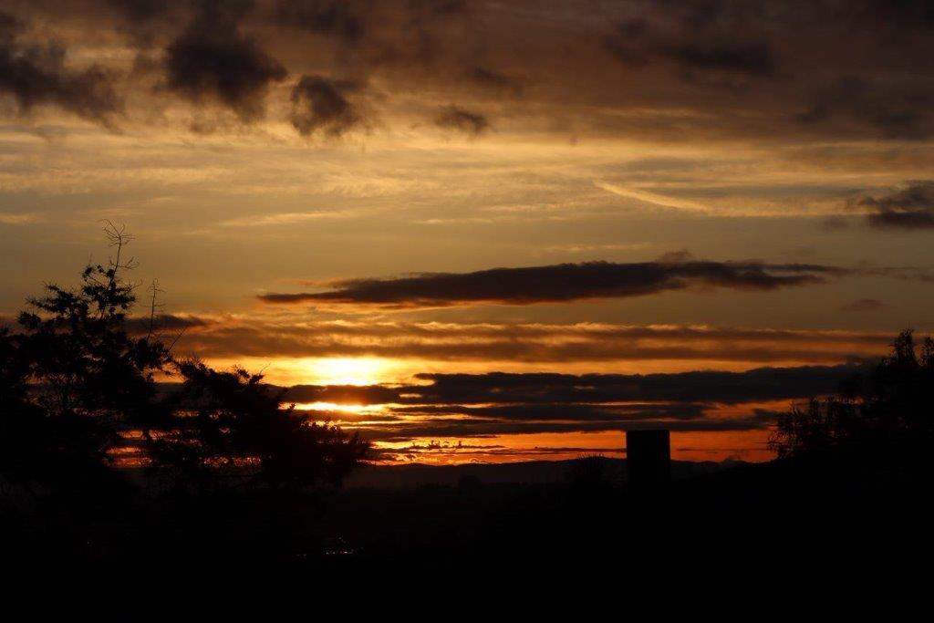 A sunset over a city

Description automatically generated
