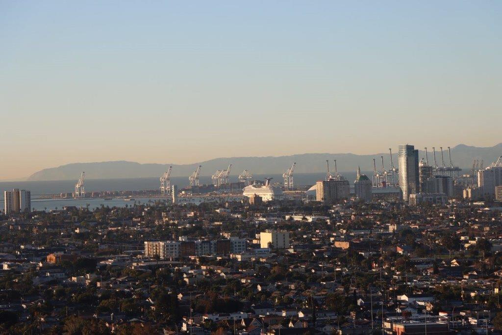 A city with cranes in the background

Description automatically generated