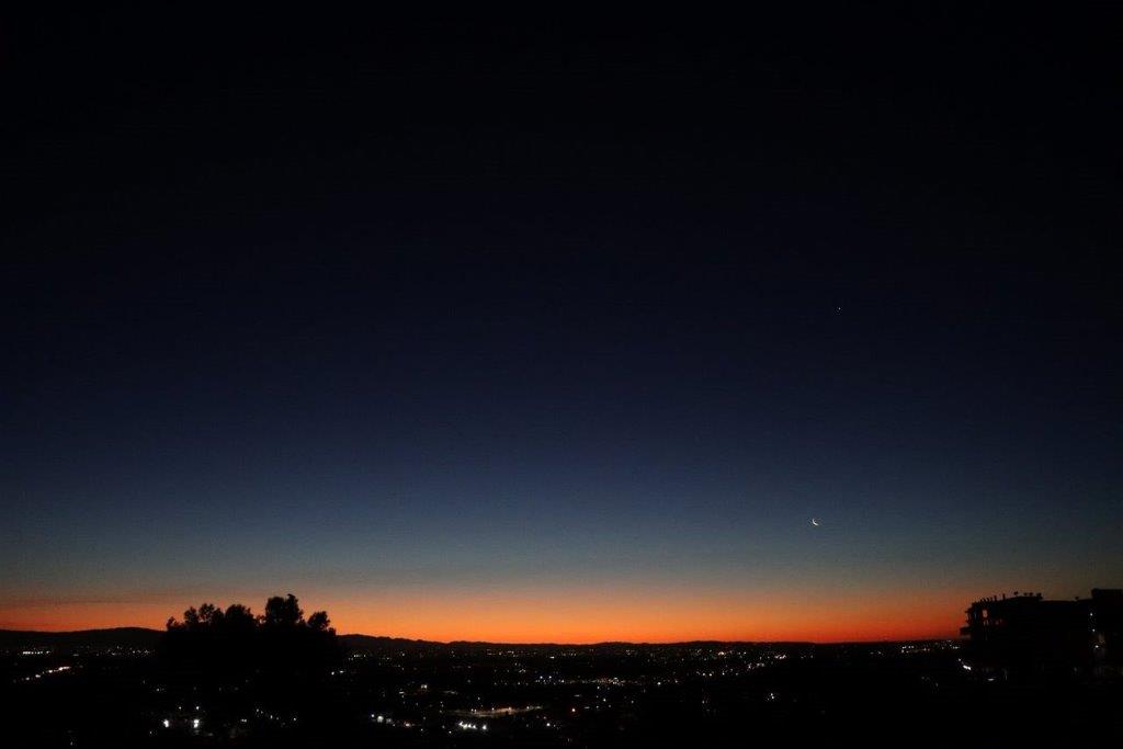 A sunset over a city

Description automatically generated
