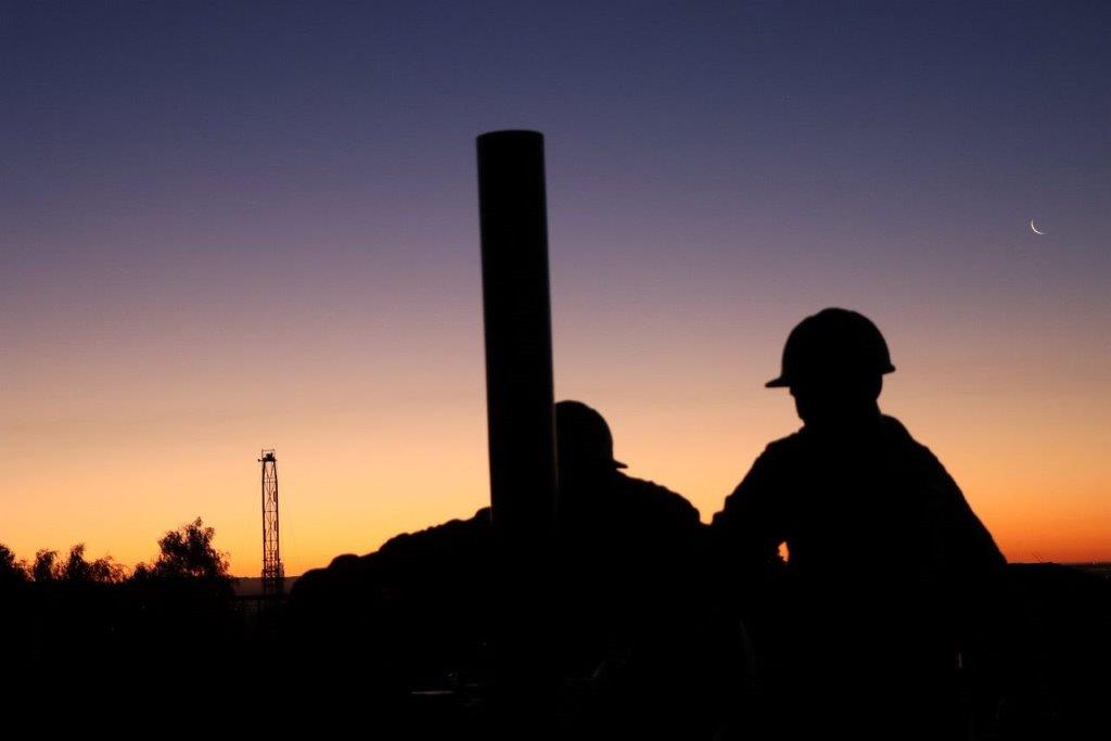 Silhouette of men in hard hats

Description automatically generated