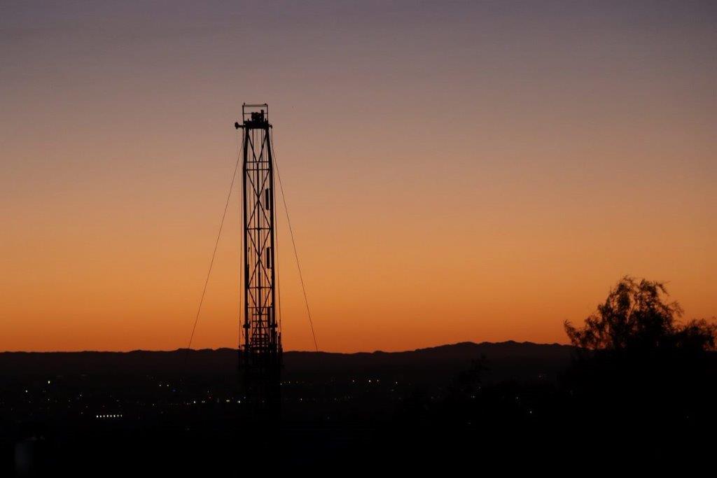 A silhouette of a tower at sunset

Description automatically generated