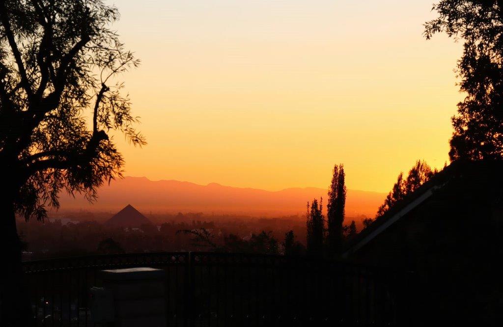 A sunset over a city

Description automatically generated
