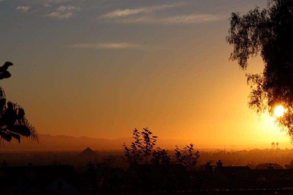 A sunset over a city

Description automatically generated