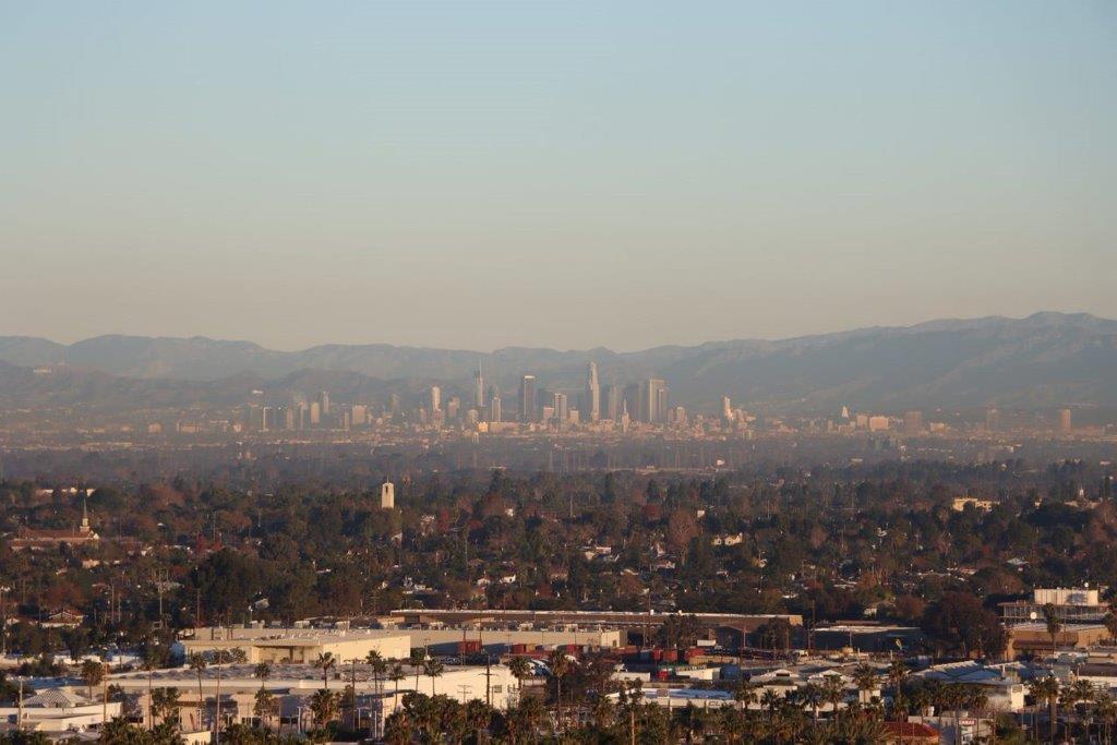 A cityscape with mountains in the background

Description automatically generated