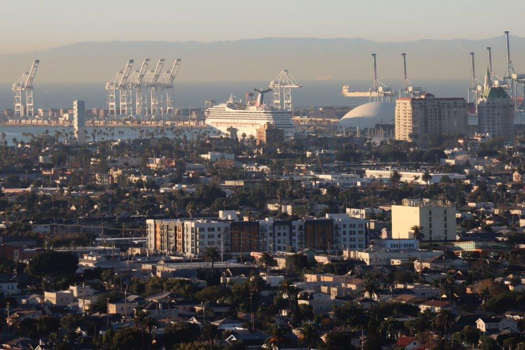 A city with cranes in the background

Description automatically generated