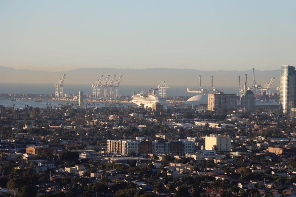 A city with cranes in the background

Description automatically generated