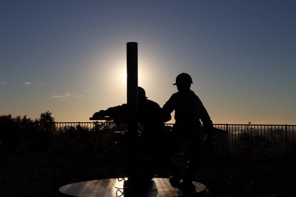 Silhouette of men in hardhats and helmets

Description automatically generated