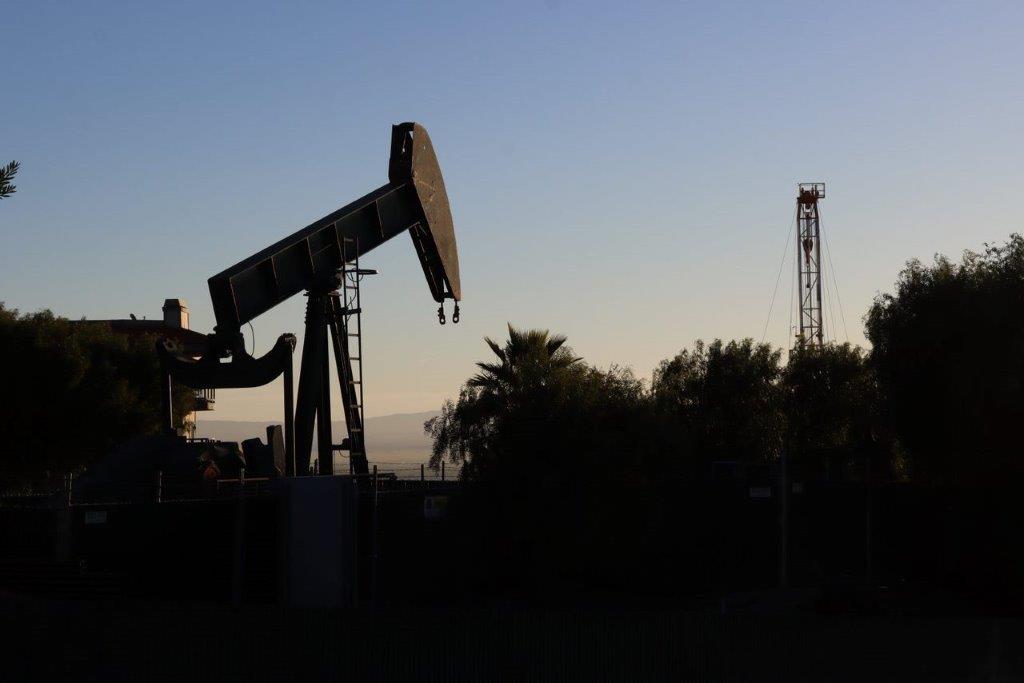 A silhouette of a oil rig

Description automatically generated