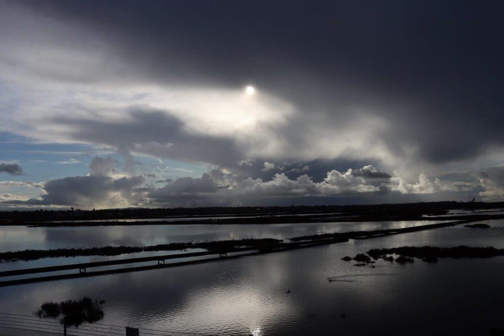 A cloudy sky over a river

Description automatically generated