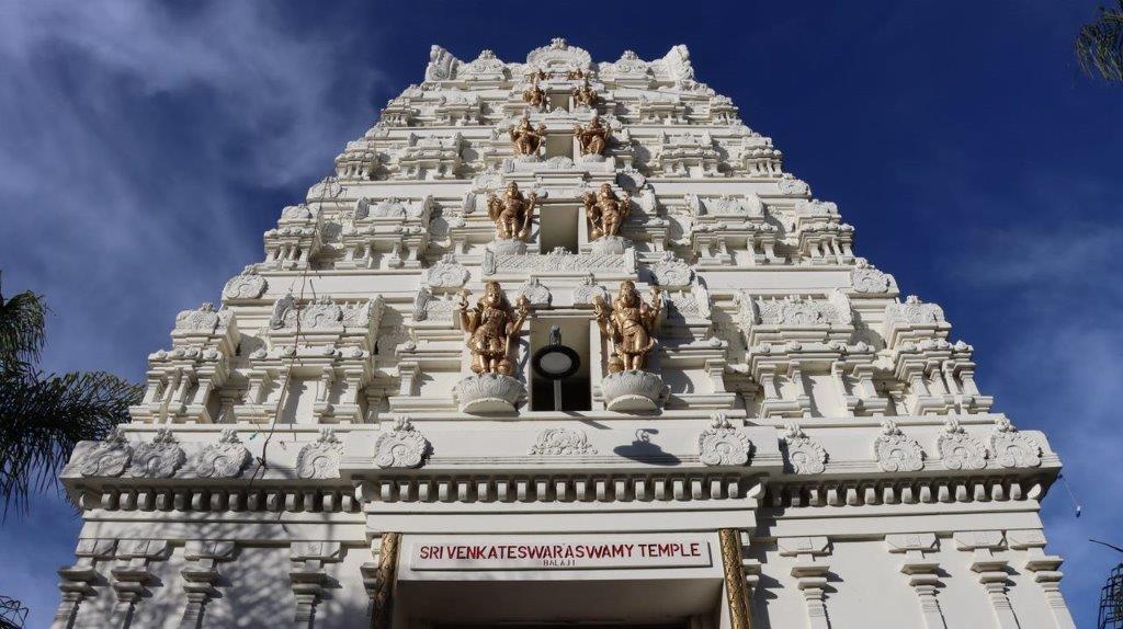 A white temple with statues on the top

Description automatically generated