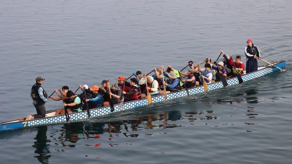 A group of people rowing a boat

Description automatically generated