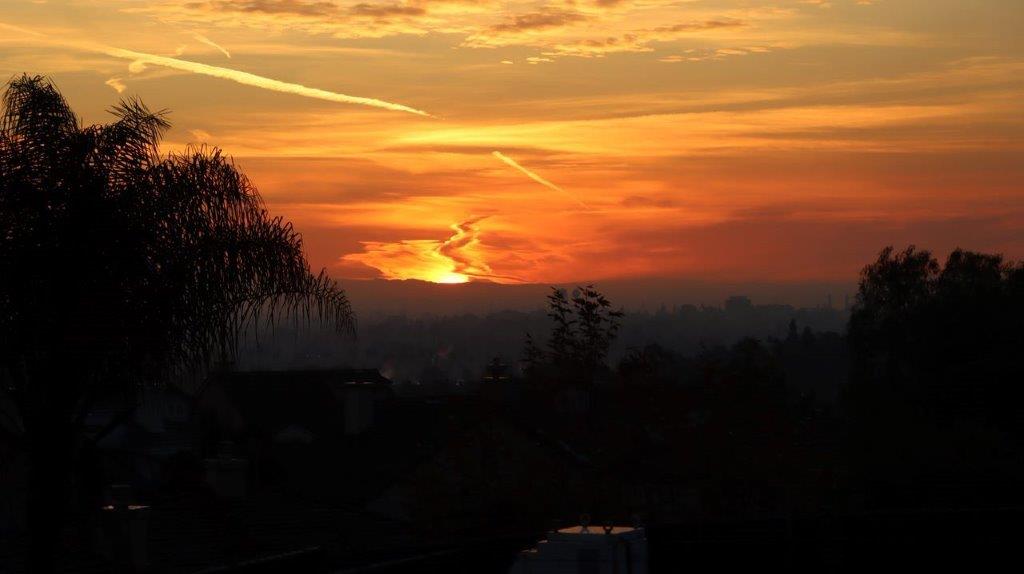 A sunset over a city

Description automatically generated