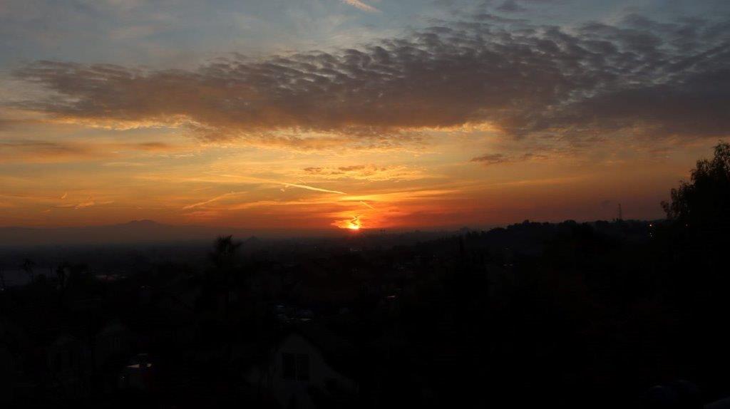 A sunset over a city

Description automatically generated