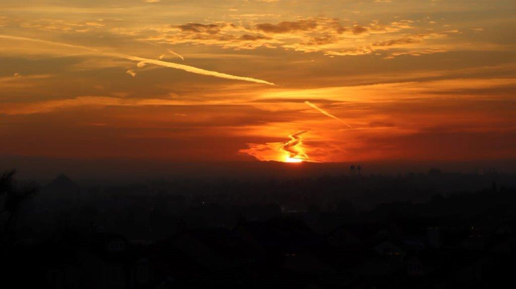 A sunset over a city

Description automatically generated