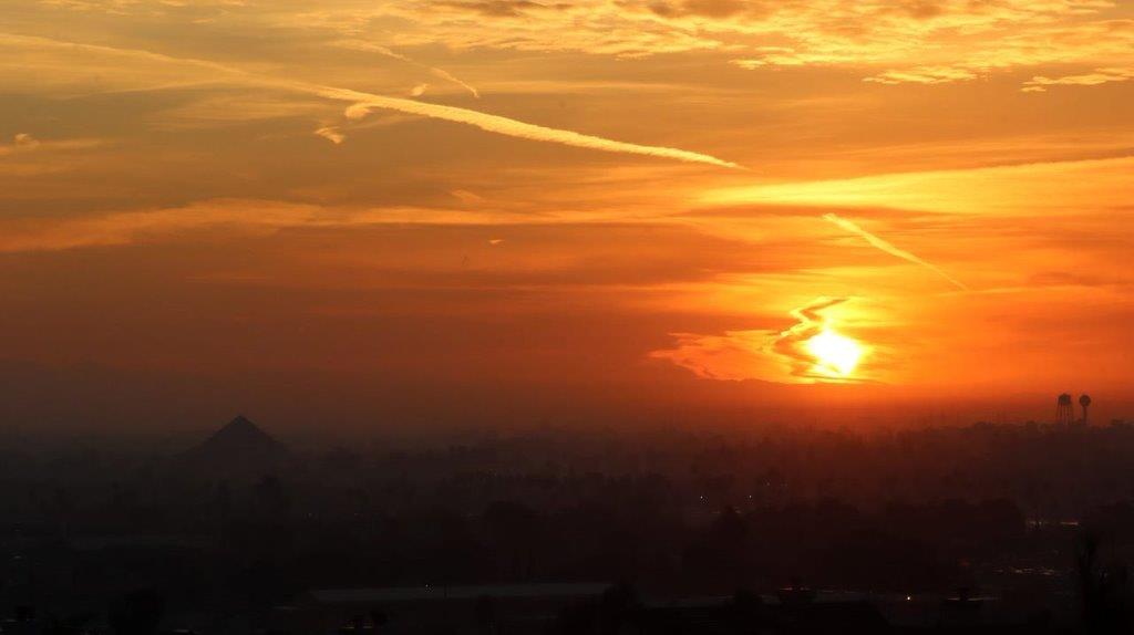 A sunset over a city

Description automatically generated