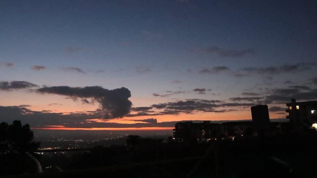 A sunset over a city

Description automatically generated