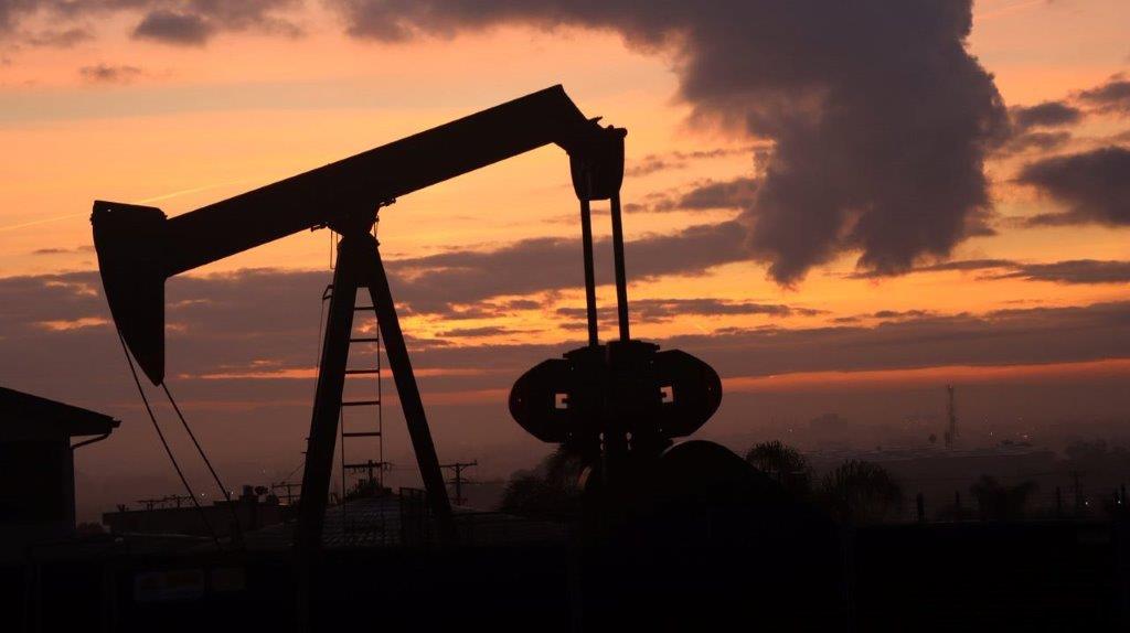 A silhouette of a pumpjack

Description automatically generated