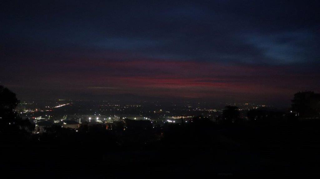 A city at night with a cloudy sky

Description automatically generated
