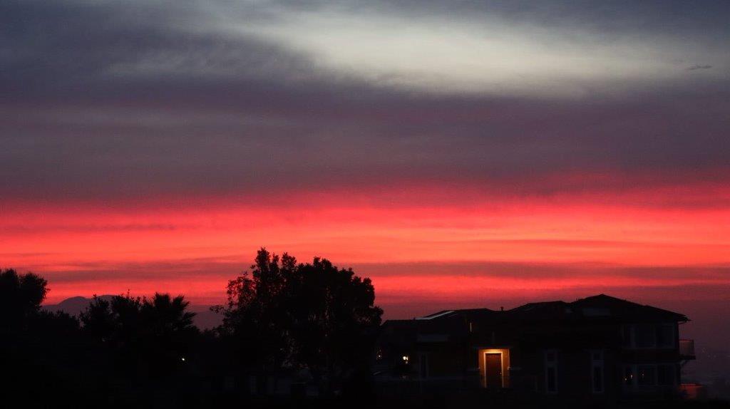 A sunset over a house

Description automatically generated
