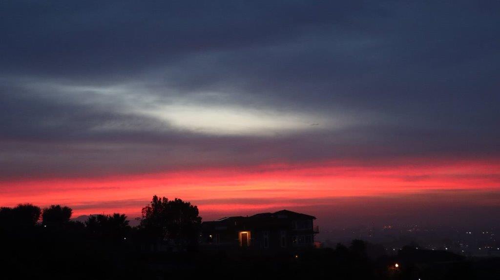 A sunset over a house

Description automatically generated