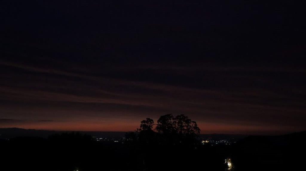 A dark sky with clouds and trees

Description automatically generated
