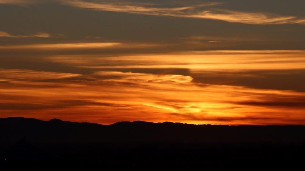 A sunset over a mountain

Description automatically generated