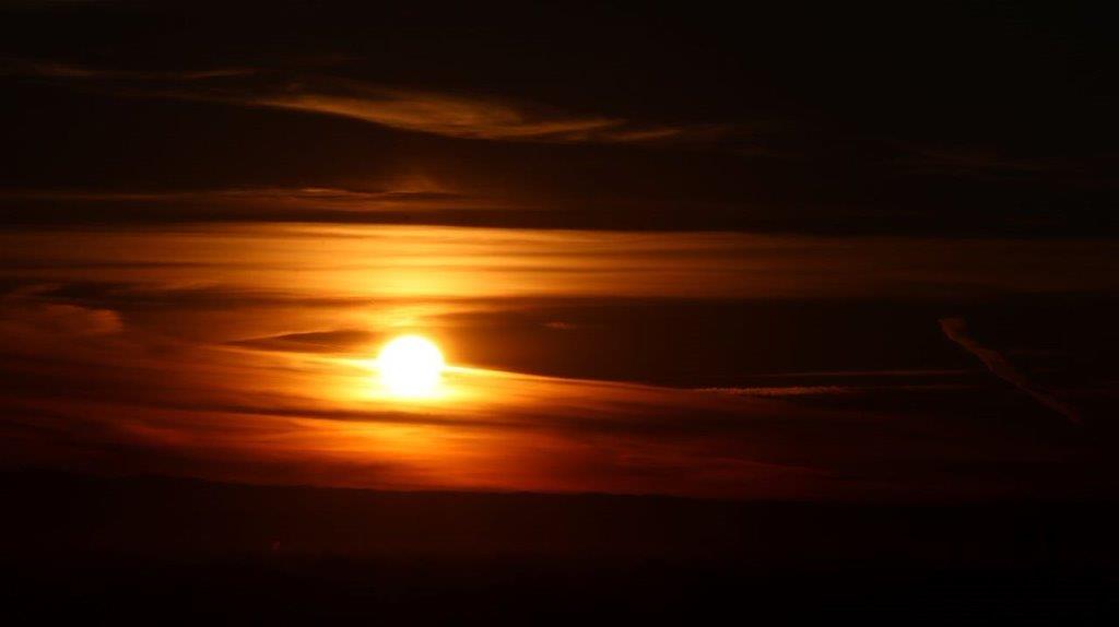 A sunset with clouds in the sky

Description automatically generated