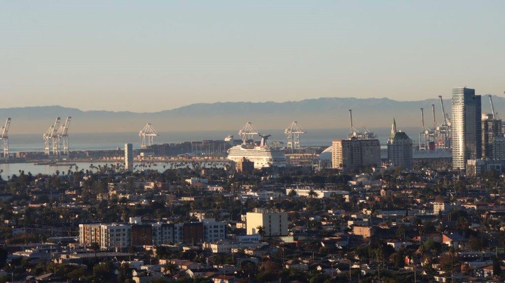 A city with cranes in the background

Description automatically generated