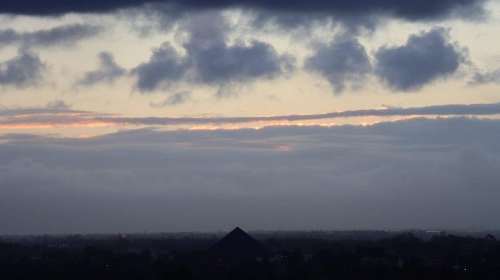 A cloudy sky with a building in the distance

Description automatically generated