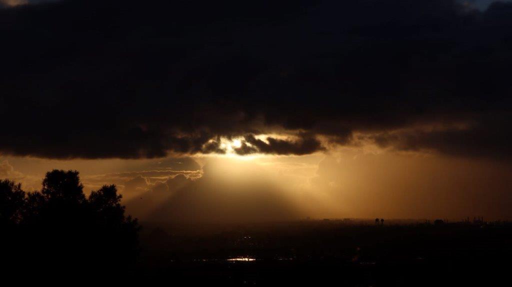 Sun shining through the clouds

Description automatically generated