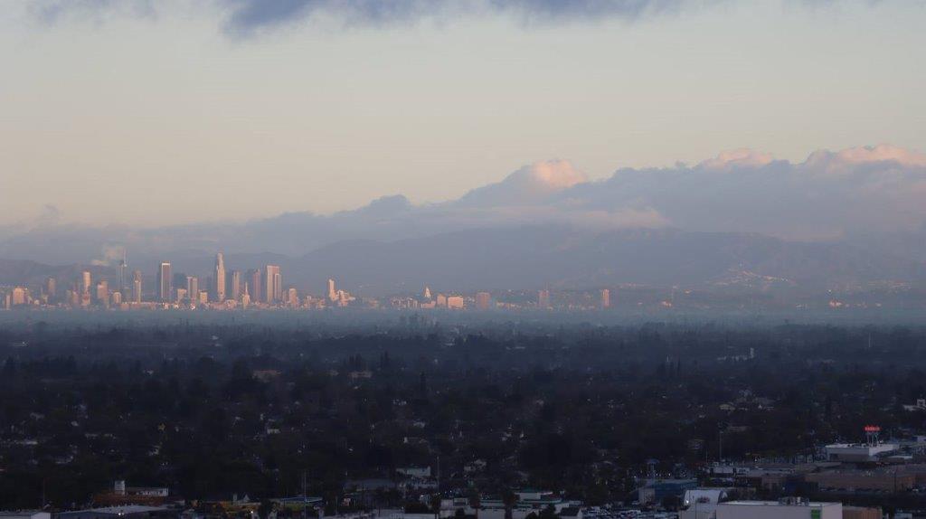 A cityscape with a mountain in the background

Description automatically generated
