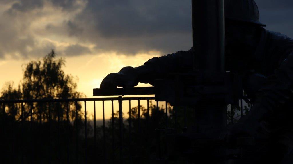 A silhouette of a person's hand on a railing

Description automatically generated
