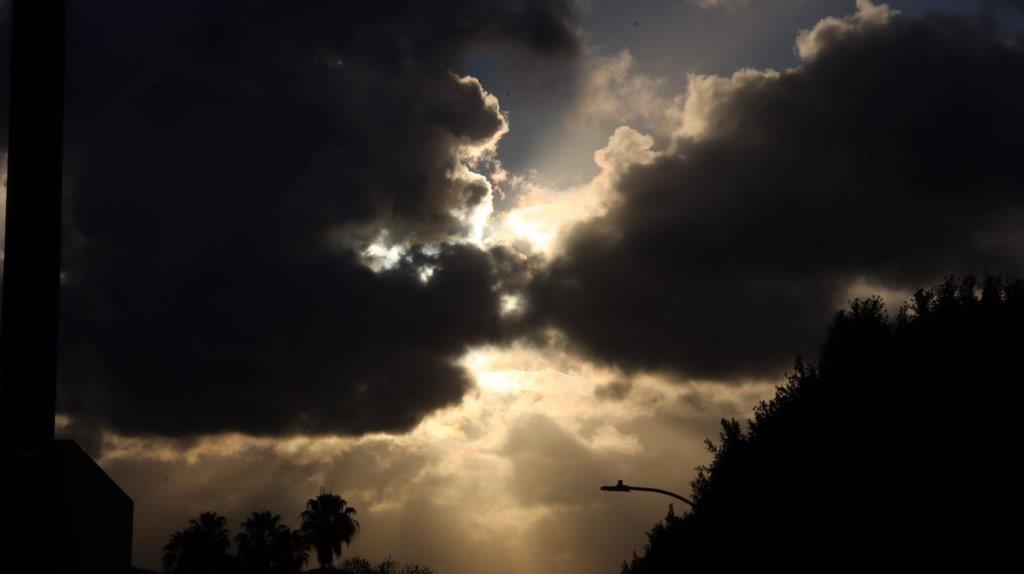 Sun shining through clouds in the sky

Description automatically generated